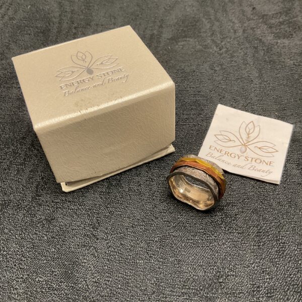Silver spinner ring with energy stone detail.