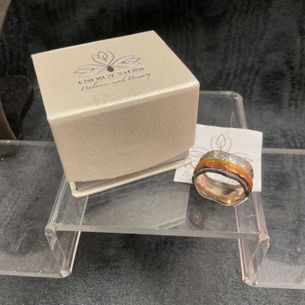 Silver spinner ring with energy stone detail.