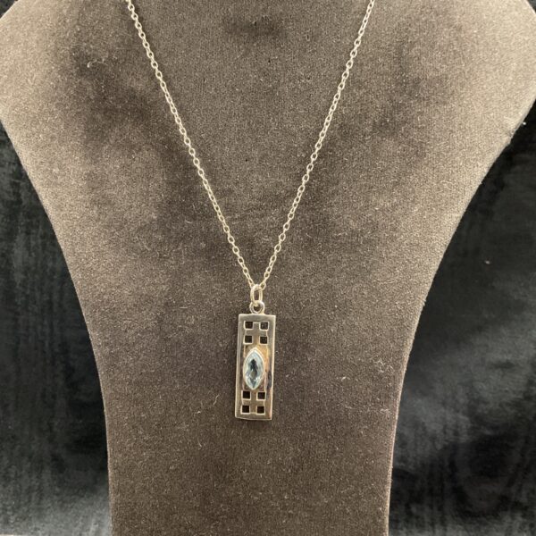 Silver topaz pendant necklace with geometric ingot design.