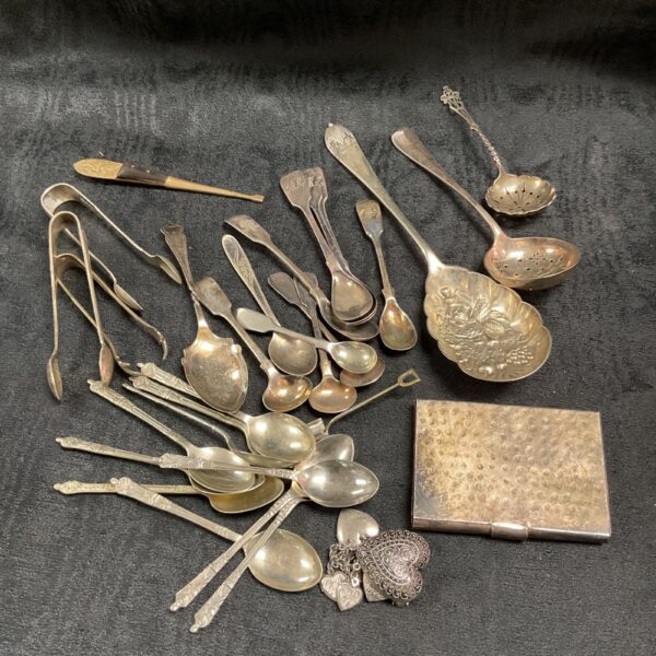 Vintage silverplate cutlery collection with cigarette case displayed.