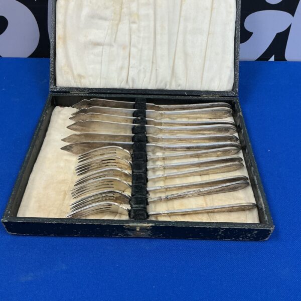 Vintage silverplate fish fork and knife set displayed in a velvet case.