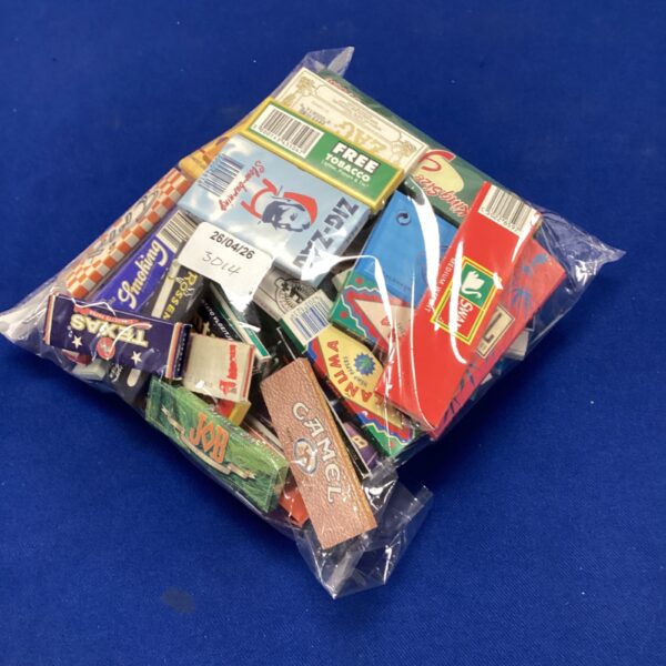 Vintage smoking papers including Swan and Rizla brands in a plastic bag.