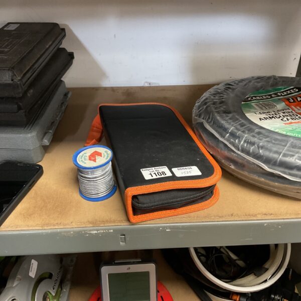 Black and orange soldering iron kit with roll of solder wire.