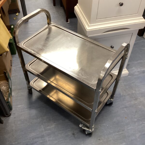 Stainless steel three-tier catering trolley for serving food.
