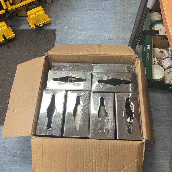 Modern stainless steel tissue dispenser on a cardboard box.