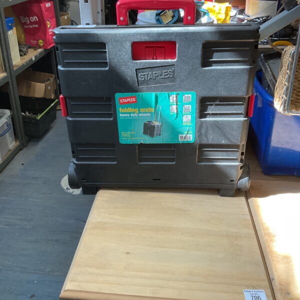 Durable Staples folding crate with heavy duty wheels for portable storage.