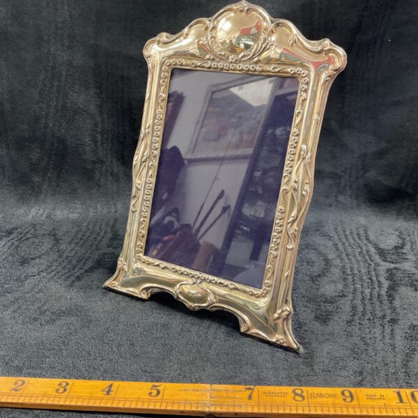 Ornate sterling silver Art Nouveau picture frame with floral details.