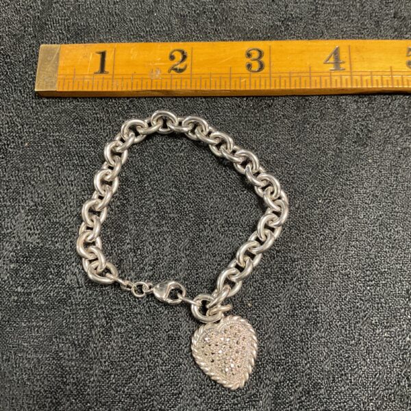 Close-up of vintage sterling silver marcasite bracelet with heart pendant.