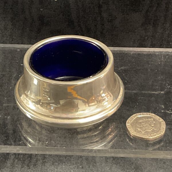 Hallmarked sterling silver salt with a vibrant blue glass liner.