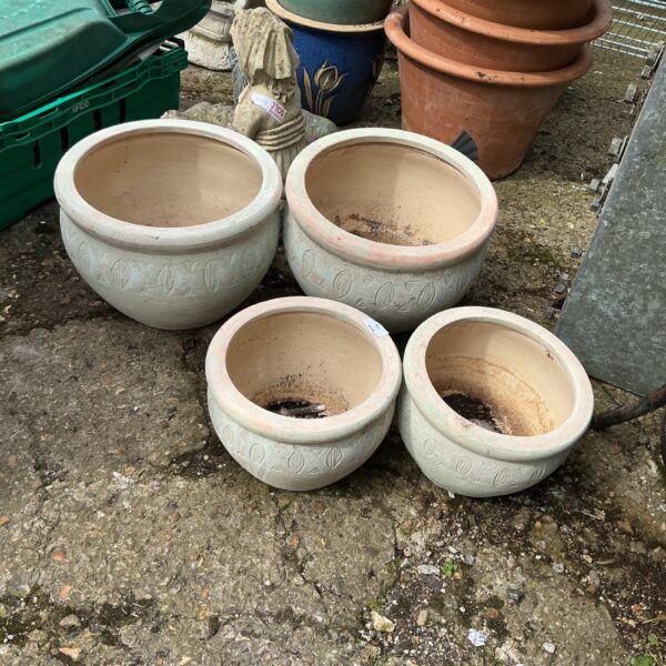 Four stone effect garden planters displayed outdoors.