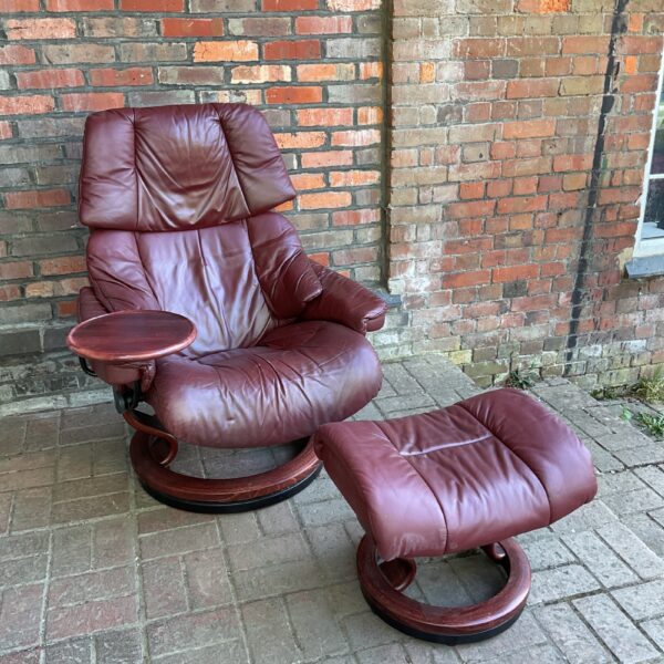 Comfortable Stressless leather armchair with footstool and drink tray.