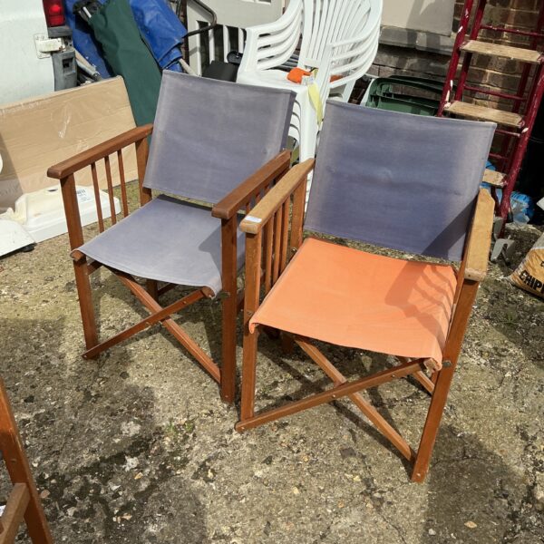 Two vintage teak folding garden chairs in a garden setting.