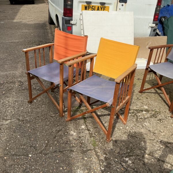 Two vintage teak folding garden chairs in a garden setting.