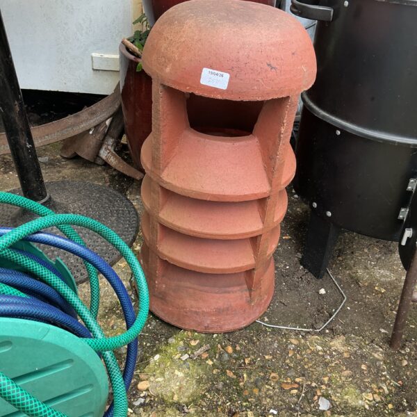 Vintage terracotta chimney cowl for garden protection.