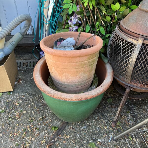 Lot of three weathered terracotta garden pots for outdoor plants.