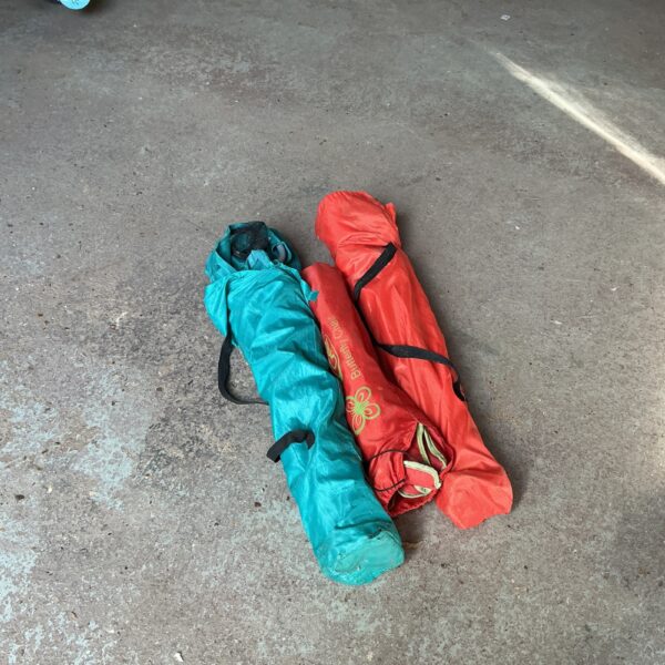 Three colourful folding camping chairs stacked together.