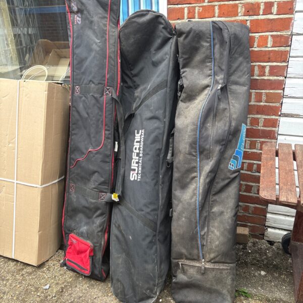 Three used snowboard cases stacked together for travel.