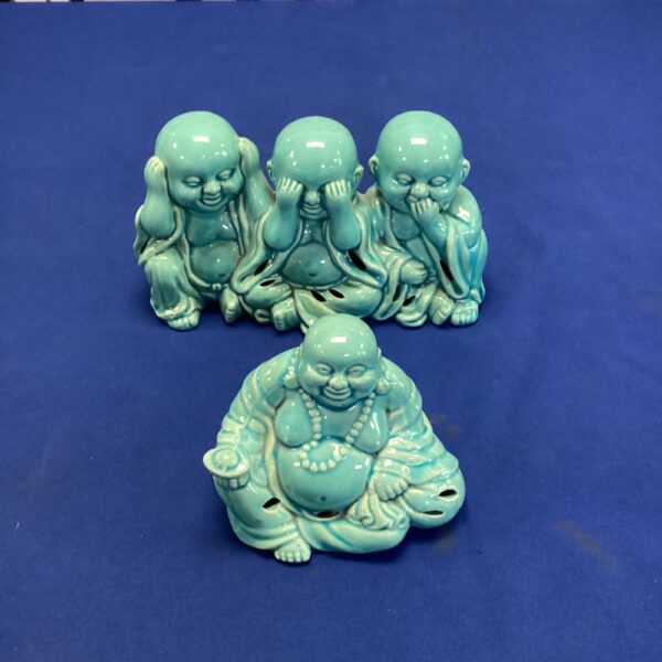 Ceramic three wise monkeys statue functioning as a potpourri holder.