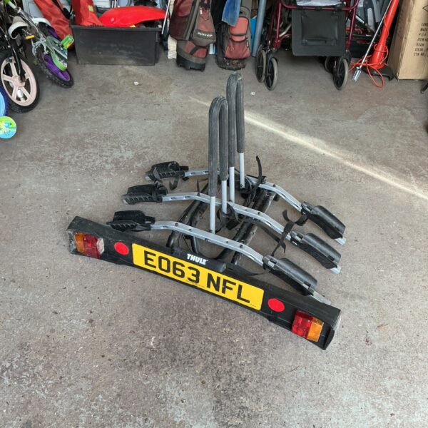 Rear-mounted Thule bike rack for carrying bicycles on a vehicle.