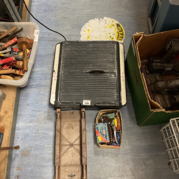 Tile cutting saw with mitre box and staple gun for DIY projects.
