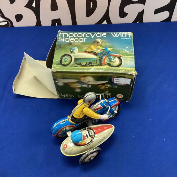 Vintage style tin motorcycle with sidecar, colourful clockwork toy.