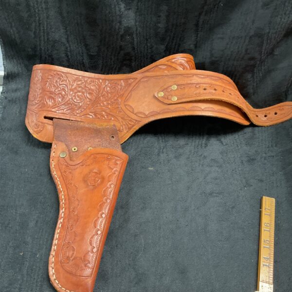 Vintage tooled leather cowboy holster with detailed floral tooling.
