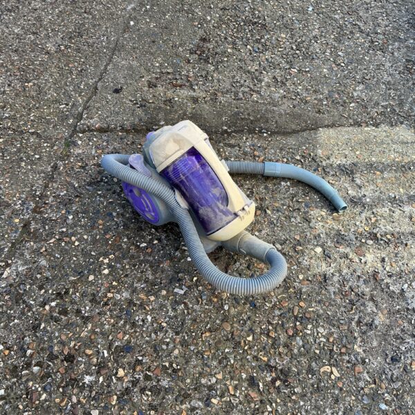 Grey and blue cylinder vacuum cleaner for home cleaning.
