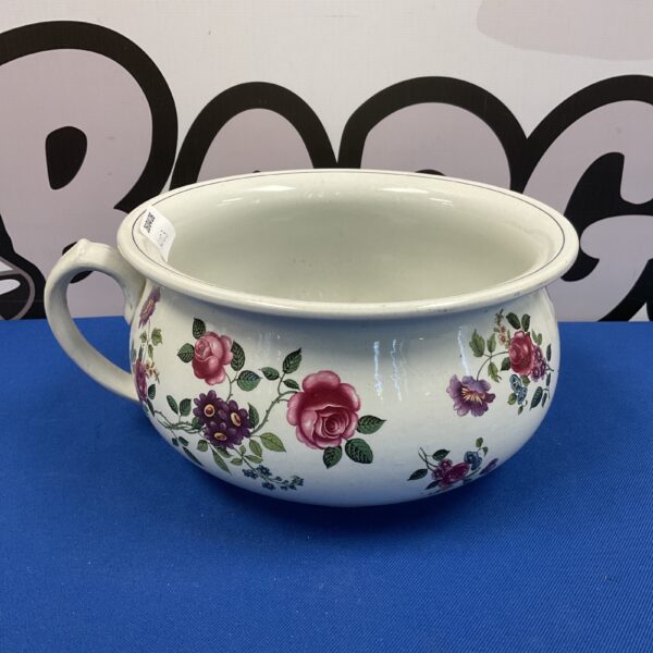 Antique Victorian chamber pot with vibrant floral pattern.