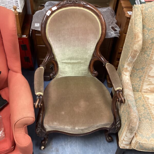 Vintage balloon back armchair with patterned upholstery and casters.