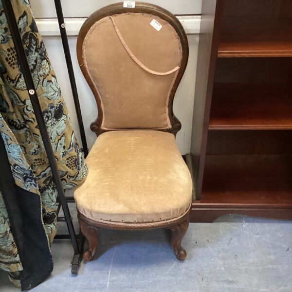 Vintage balloon back nursing chair with faded upholstery.