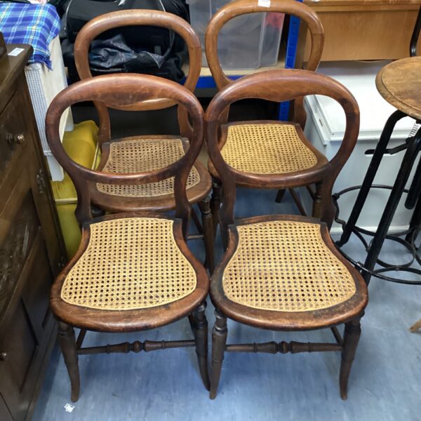 Set of four vintage balloon back rattan chairs with curved backs.