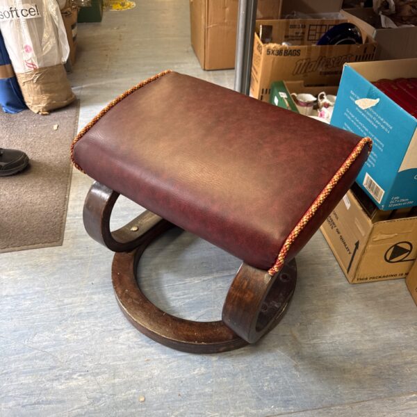 Vintage bentwood footstool with leather seat and warm patina.