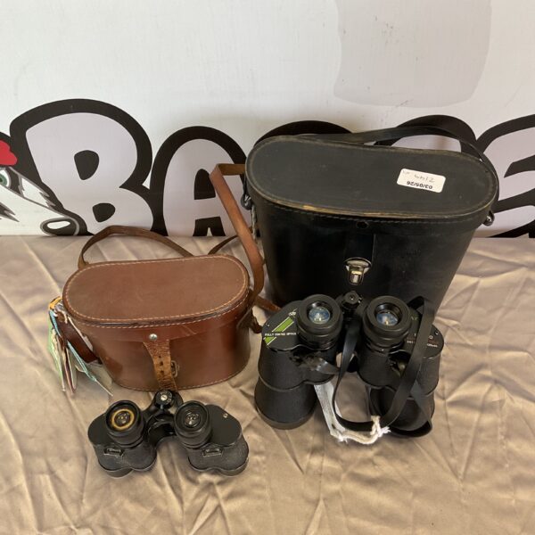 Vintage binoculars pair in leather cases, antique optics.