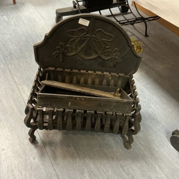 Ornate vintage black metal fireplace set with decorative detailing.