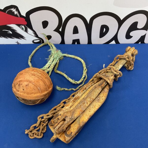 Vintage boat anchor with chain and Hercules buoy for nautical decor.