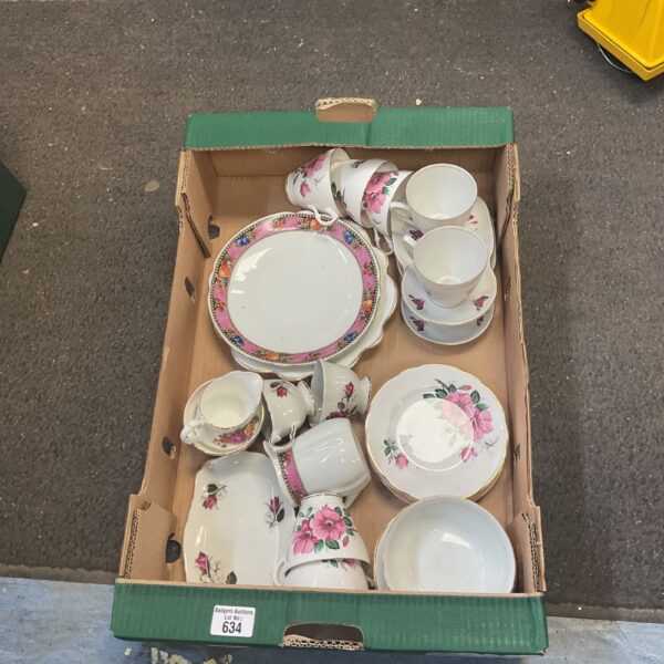 Vintage bone china tableware with floral designs in a green box.