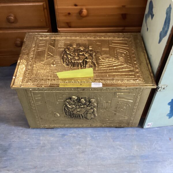 Ornate vintage brass log box with detailed relief carvings.