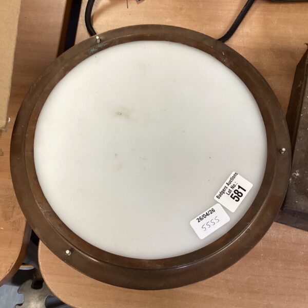 Vintage bulkhead light with a thick glass lens.