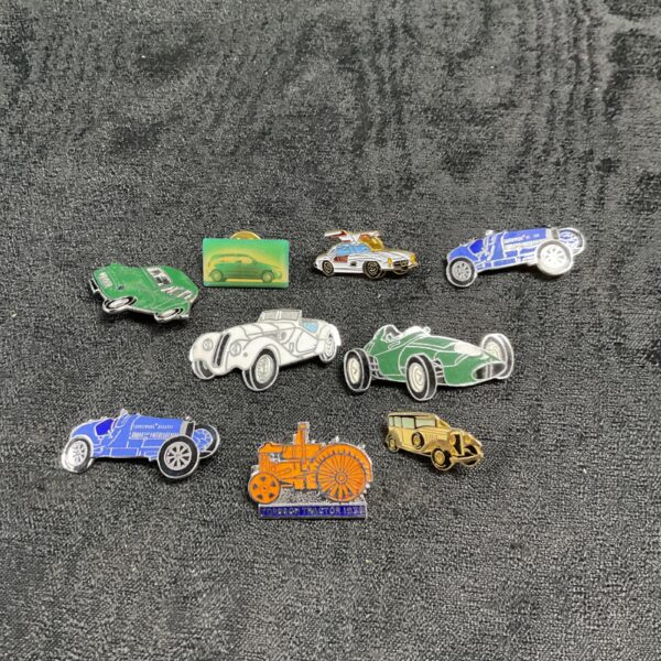 Lot of vintage car enamel pin badges, classic automotive collectibles.