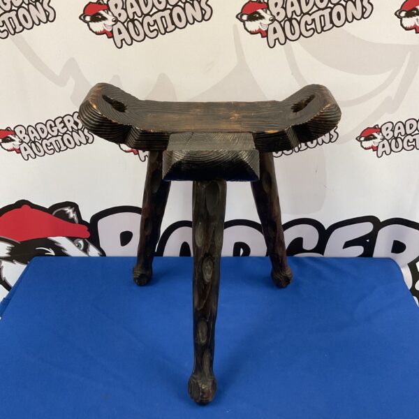 Vintage carved wood milking stool with tripod legs.