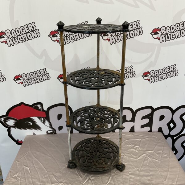 Vintage cast iron four-tier pot stand for kitchen display.
