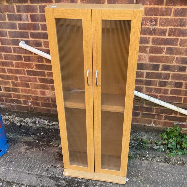 Vintage chipboard cabinet with textured glass doors for storage.