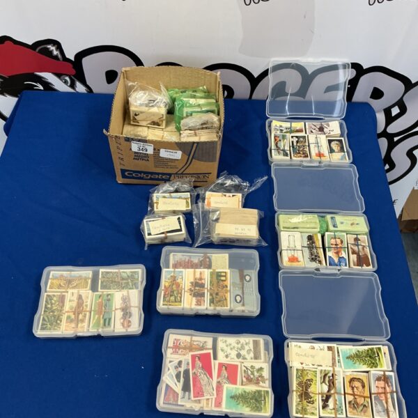 Large collection of vintage cigarette cards in a cardboard box.