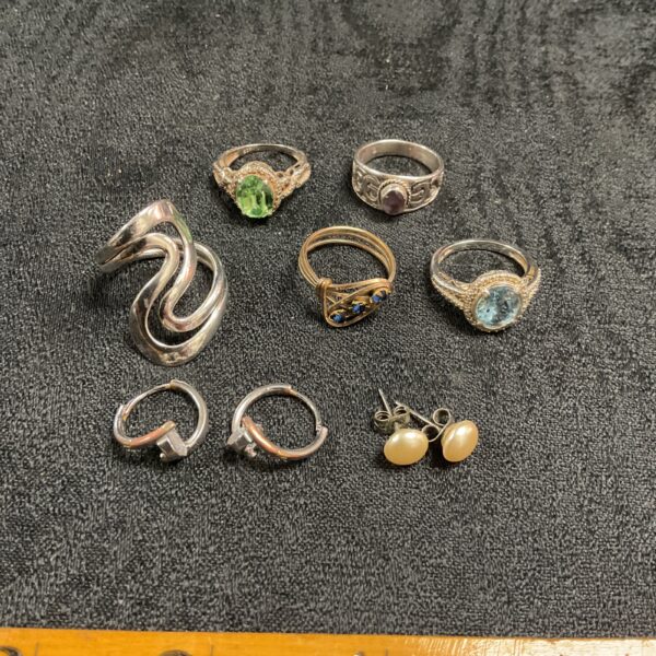 Vintage costume jewellery lot featuring colourful rings and silver earrings.