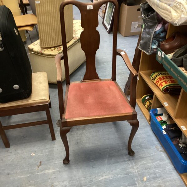 Side view of a vintage wooden dining armchair with upholstered seat.