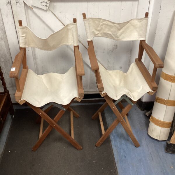 Two vintage wooden director chairs with canvas seating.