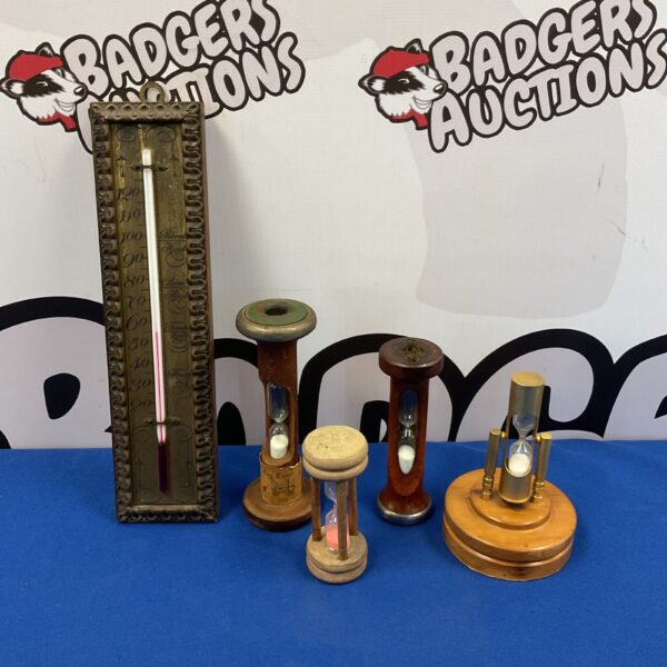 Vintage egg timers and thermometer on display, retro kitchen collectibles.