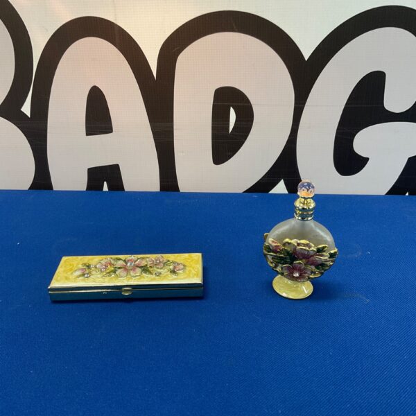 Vintage enamel perfume bottle with floral design and matching pillbox.