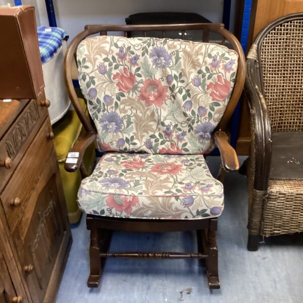 Vintage ercol rocking chair with patterned upholstery and beech frame.