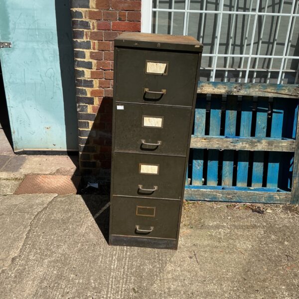 Vintage metal filing cabinet with four drawers, showing signs of age.